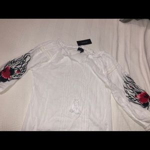 White shirt with floral design on the sleeves